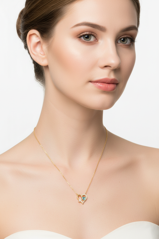 Model wearing gold heart aqua CZ necklace