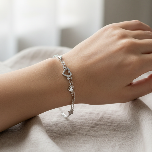 Woman's hand wearing heart charm bracelet
